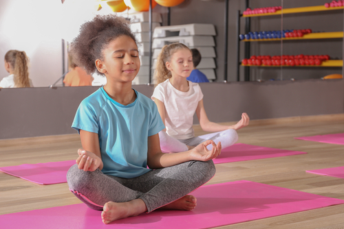 Children doing yoga on mats
