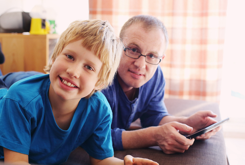 Smiling boy and parent looking at a tablet together