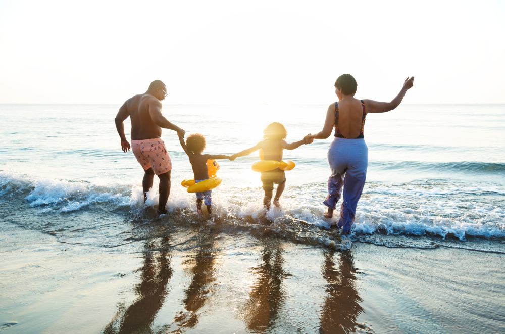 Family running into the waves at the beach
